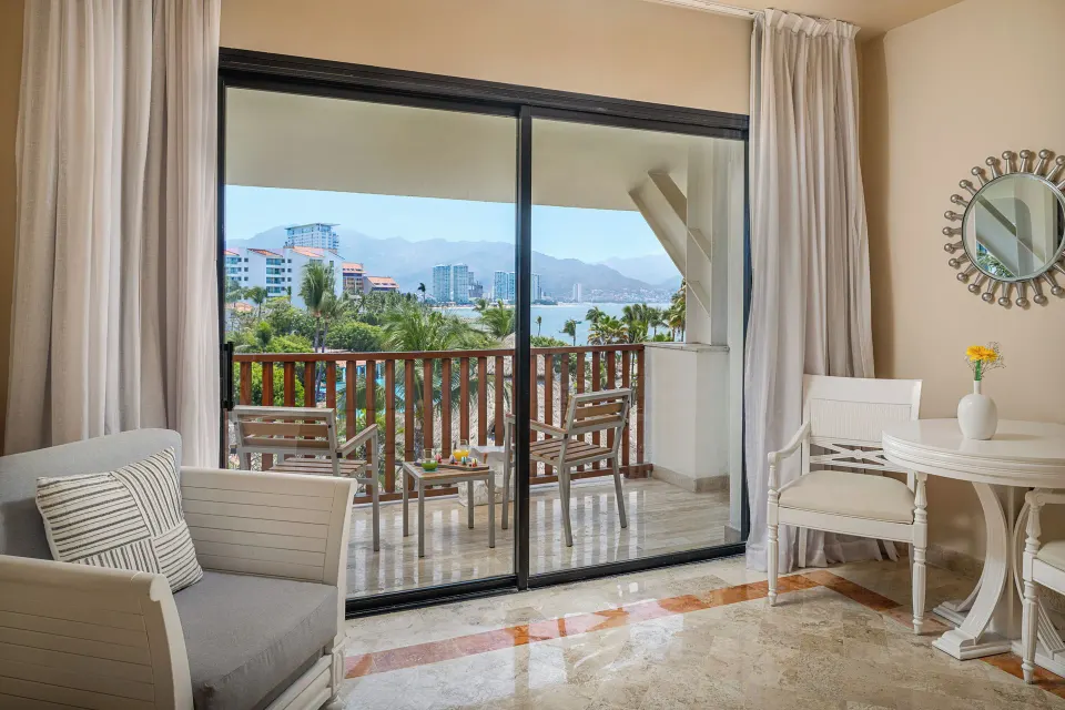 Deluxe Room Sea View sitting area with balcony and bay view at Melia Puerto Vallarta.