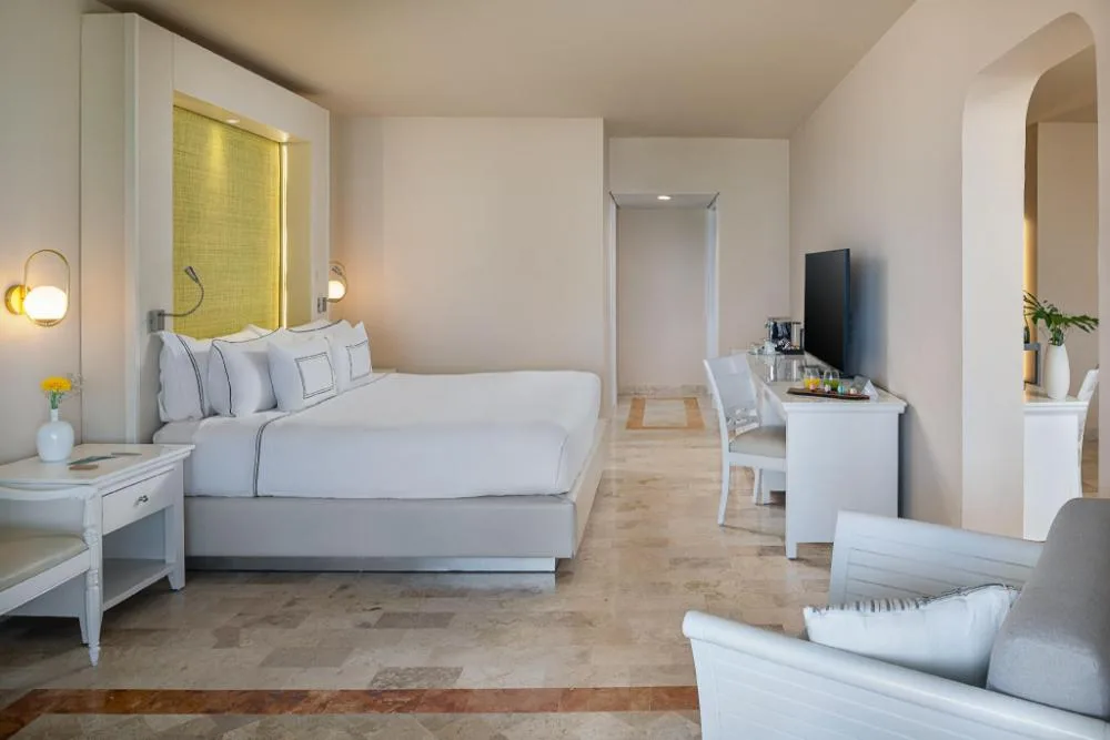 Junior Suite Sea View bedroom with king bed and seating at Melia Puerto Vallarta.