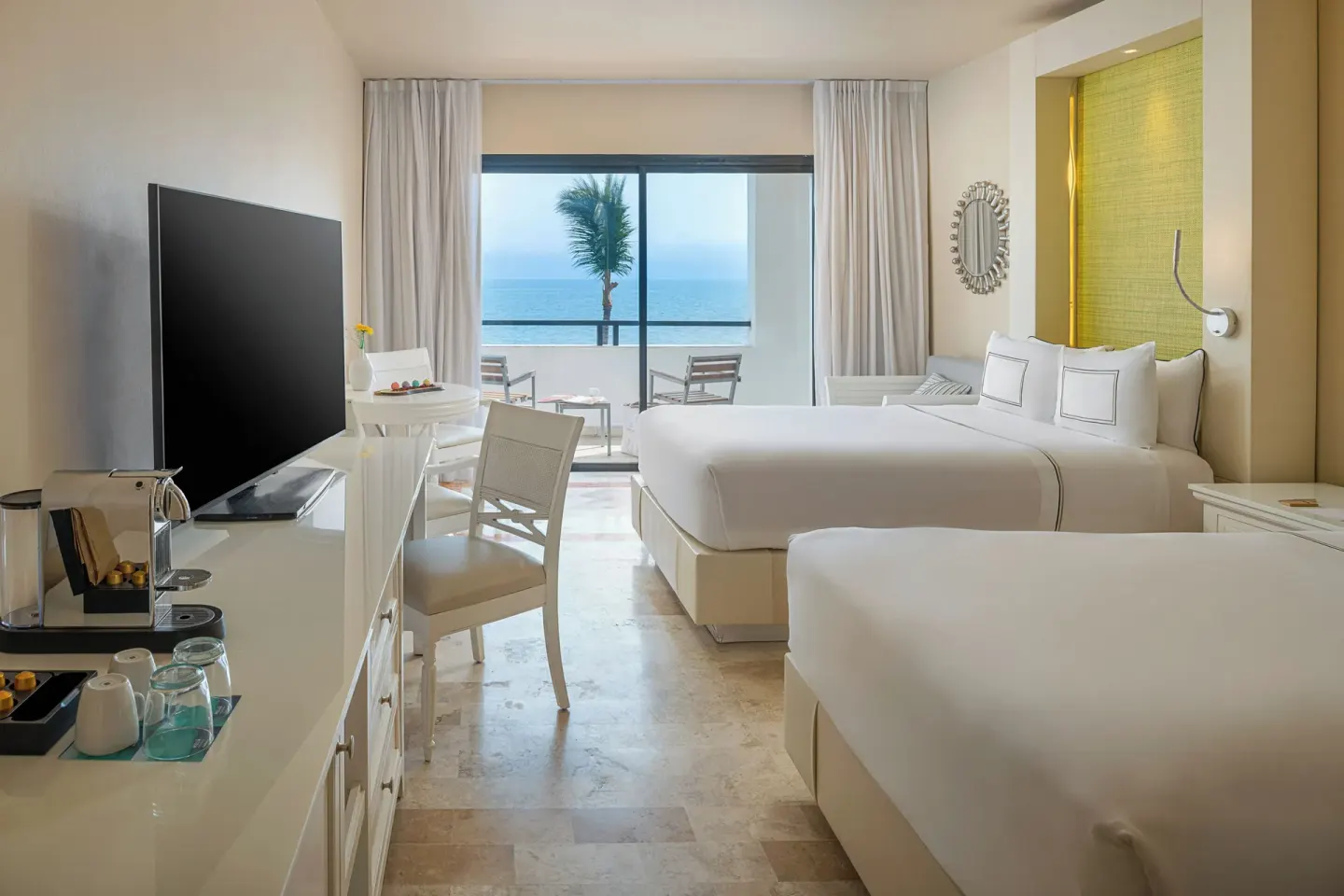 Premium Ocean Front room with two beds, TV, desk, and sea-facing balcony at Melia Puerto Vallarta.
