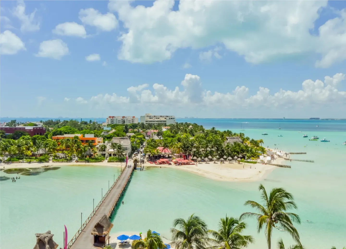 Aerial view of the pier, beaches, palms, and turquoise water at Mia Reef Isla Mujeres.