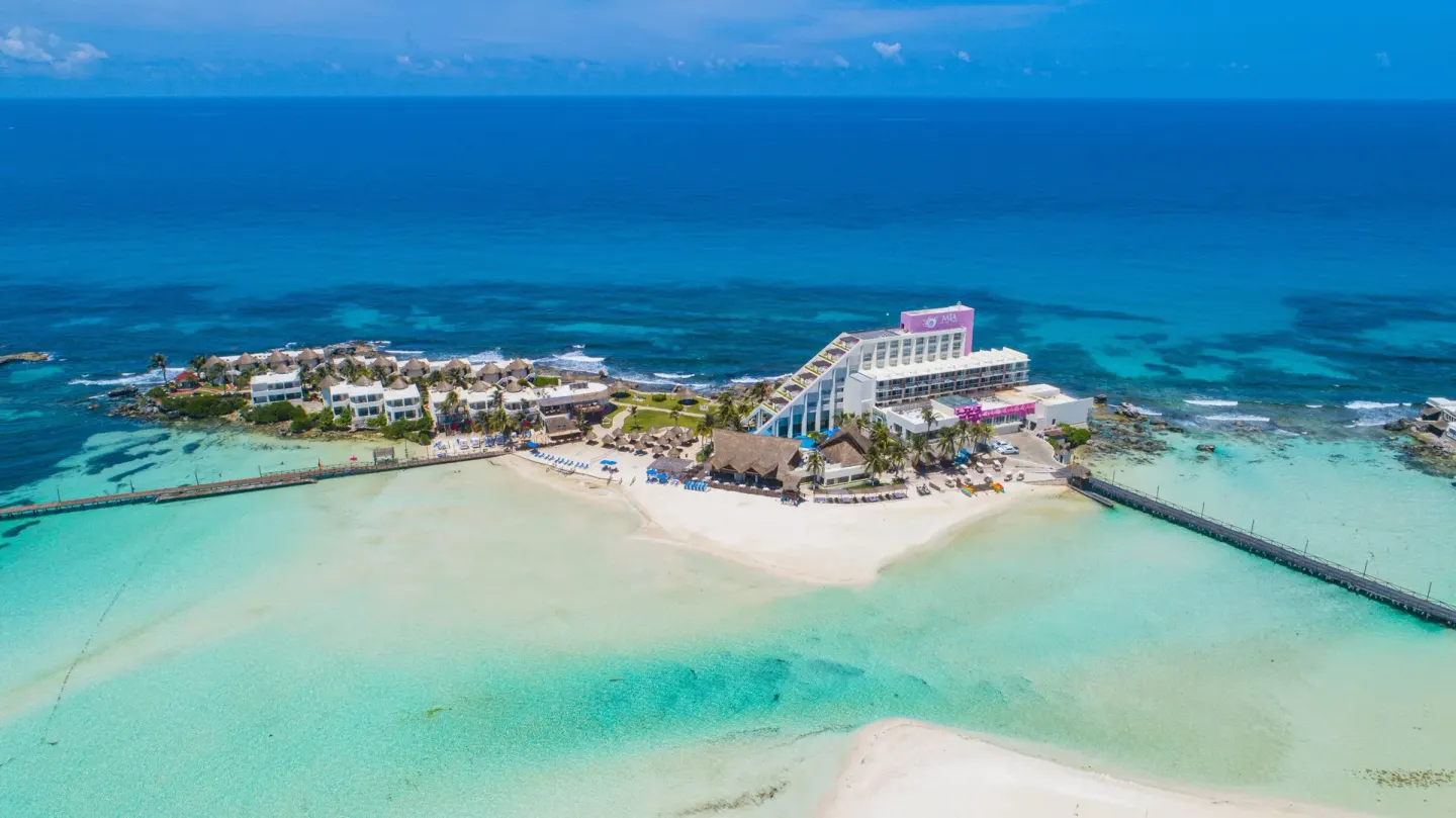 Aerial view of Mia Reef Isla Mujeres on a small island surrounded by turquoise water.