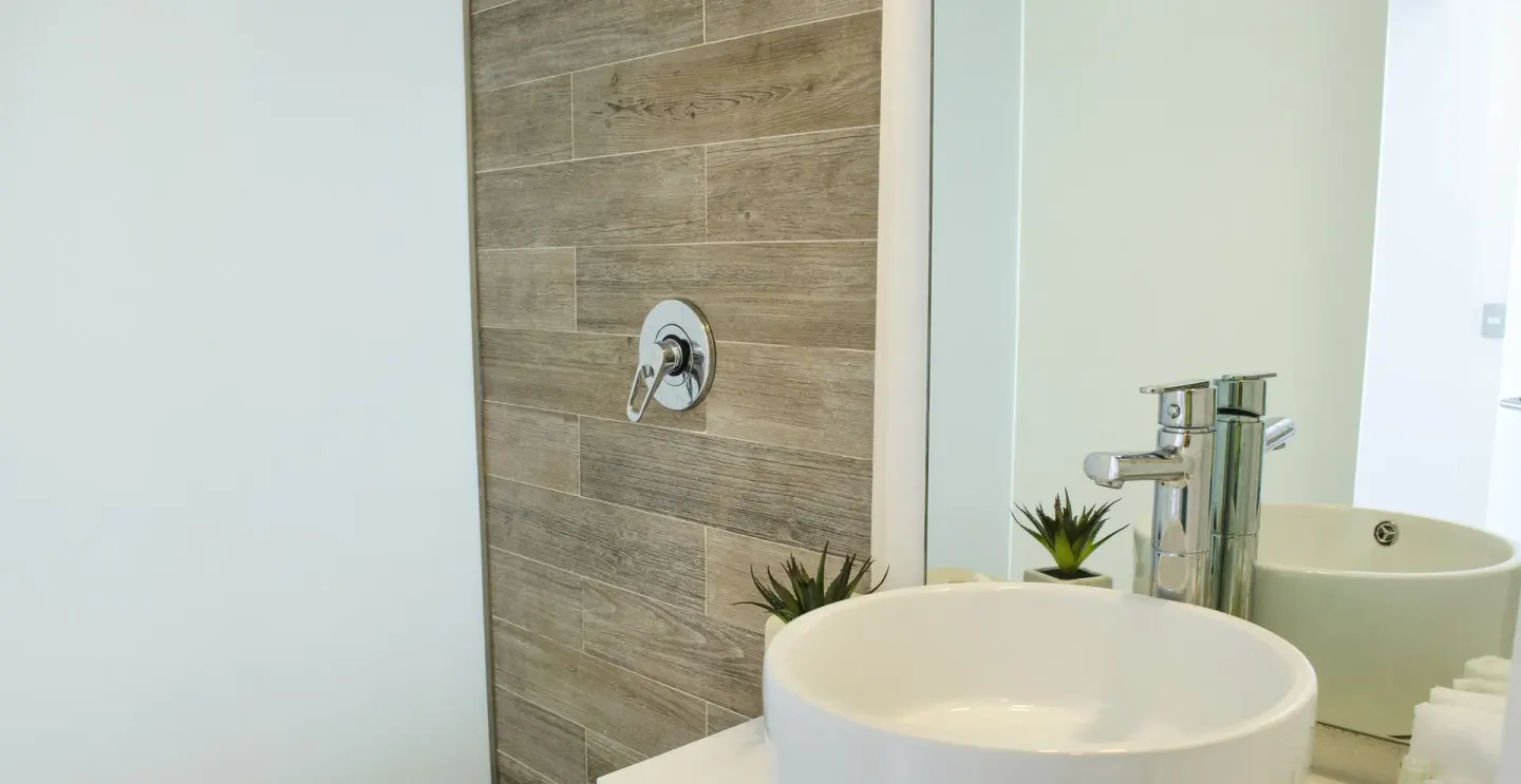 Bathroom vanity and shower controls with wood-look tile at Mia Reef Isla Mujeres.