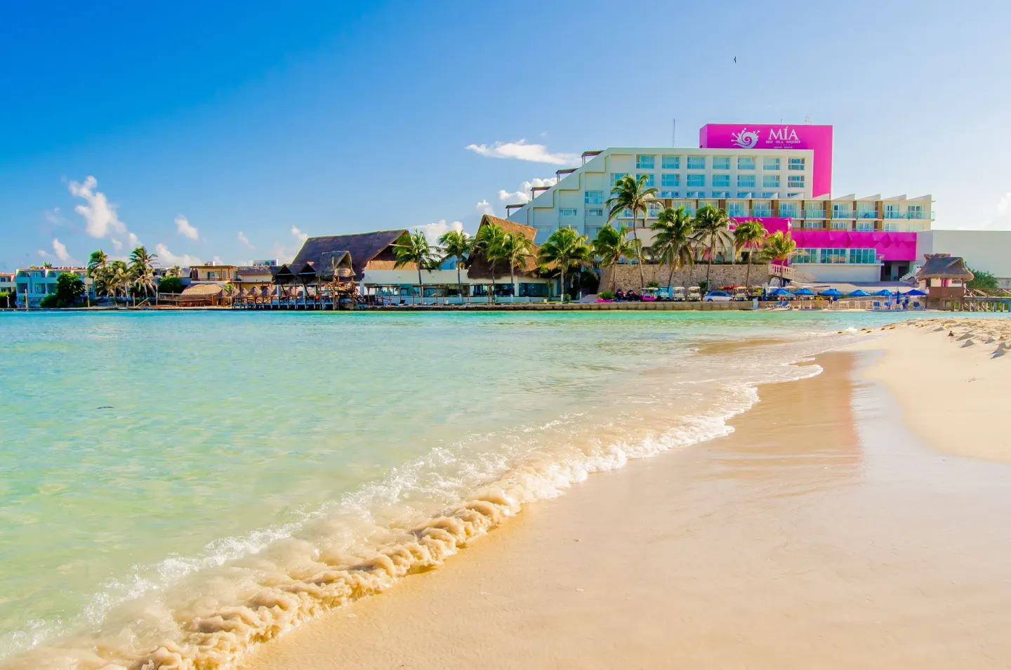 Beachfront resort building and calm turquoise water at Mia Reef Isla Mujeres.