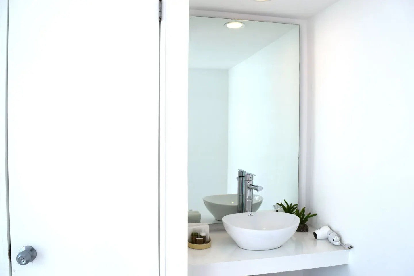 Compact bathroom vanity with round vessel sink at Mia Reef Isla Mujeres.