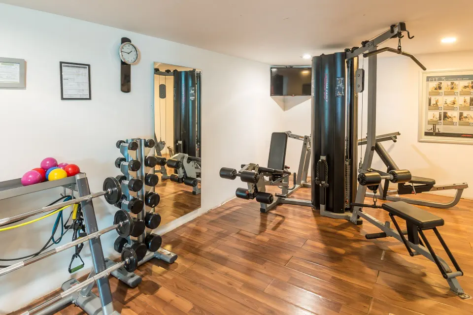 Fitness room with weights, cable machine, bench, and exercise balls at Mia Reef Isla Mujeres.