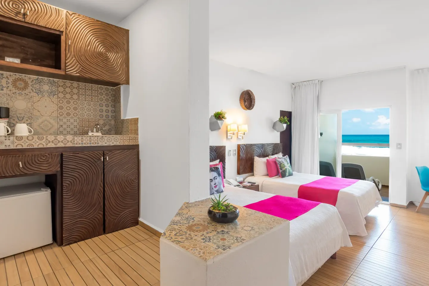Two-bed guest room with kitchenette and ocean-facing balcony at Mia Reef Isla Mujeres.