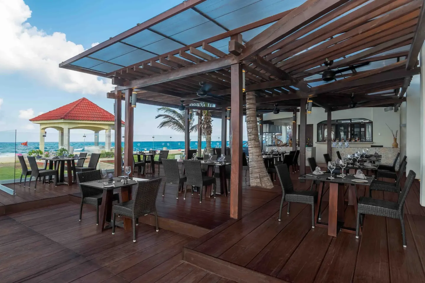 Open-air restaurant terrace with set tables and ocean views at Mia Reef Isla Mujeres.
