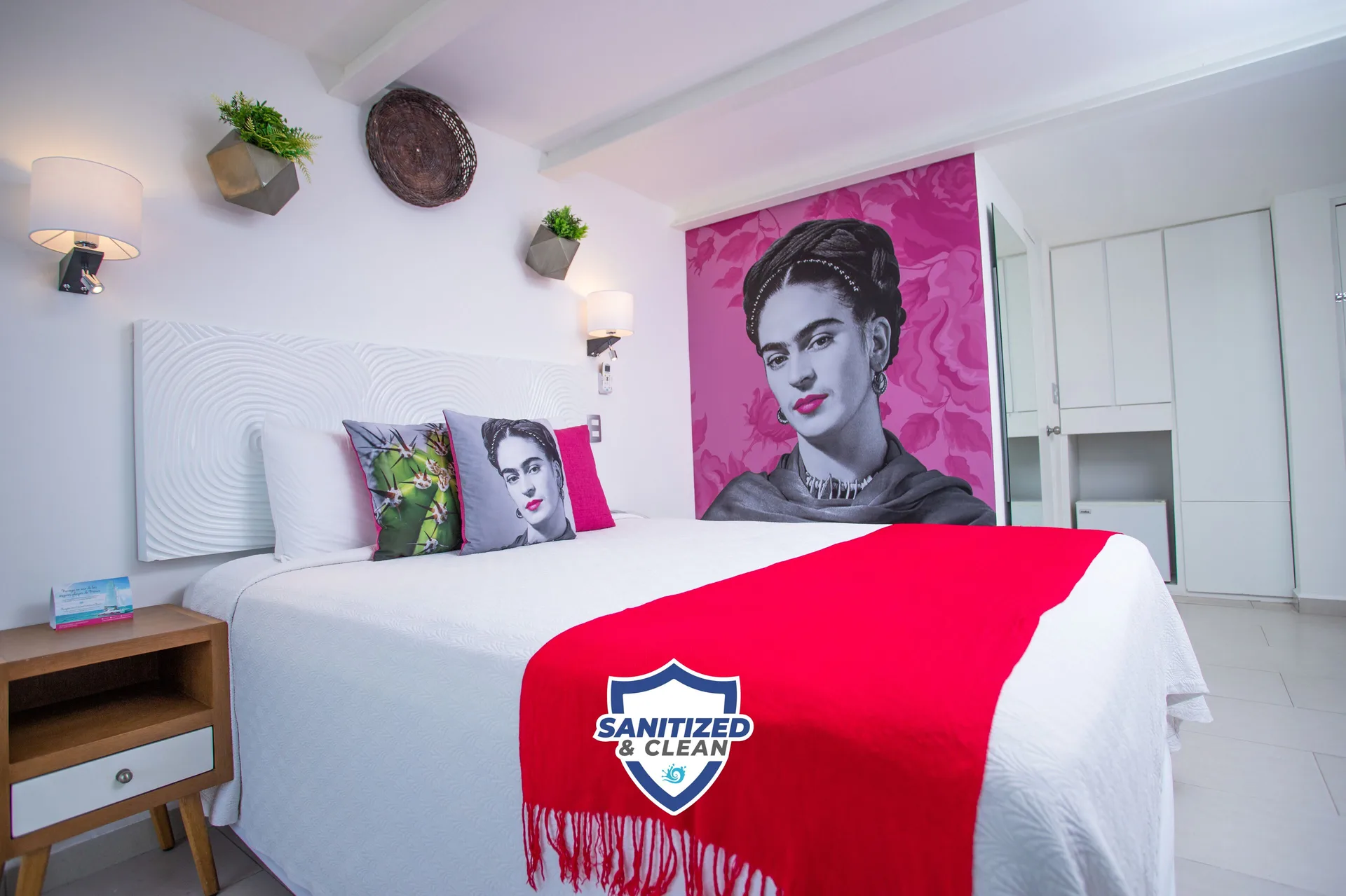 Basic Room bed with portrait mural and red throw at Mia Reef Isla Mujeres.