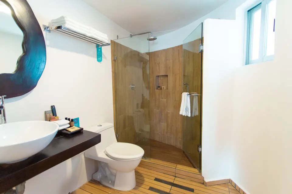 Deluxe Villa suite bathroom with glass shower and towel shelf at Mia Reef Isla Mujeres.
