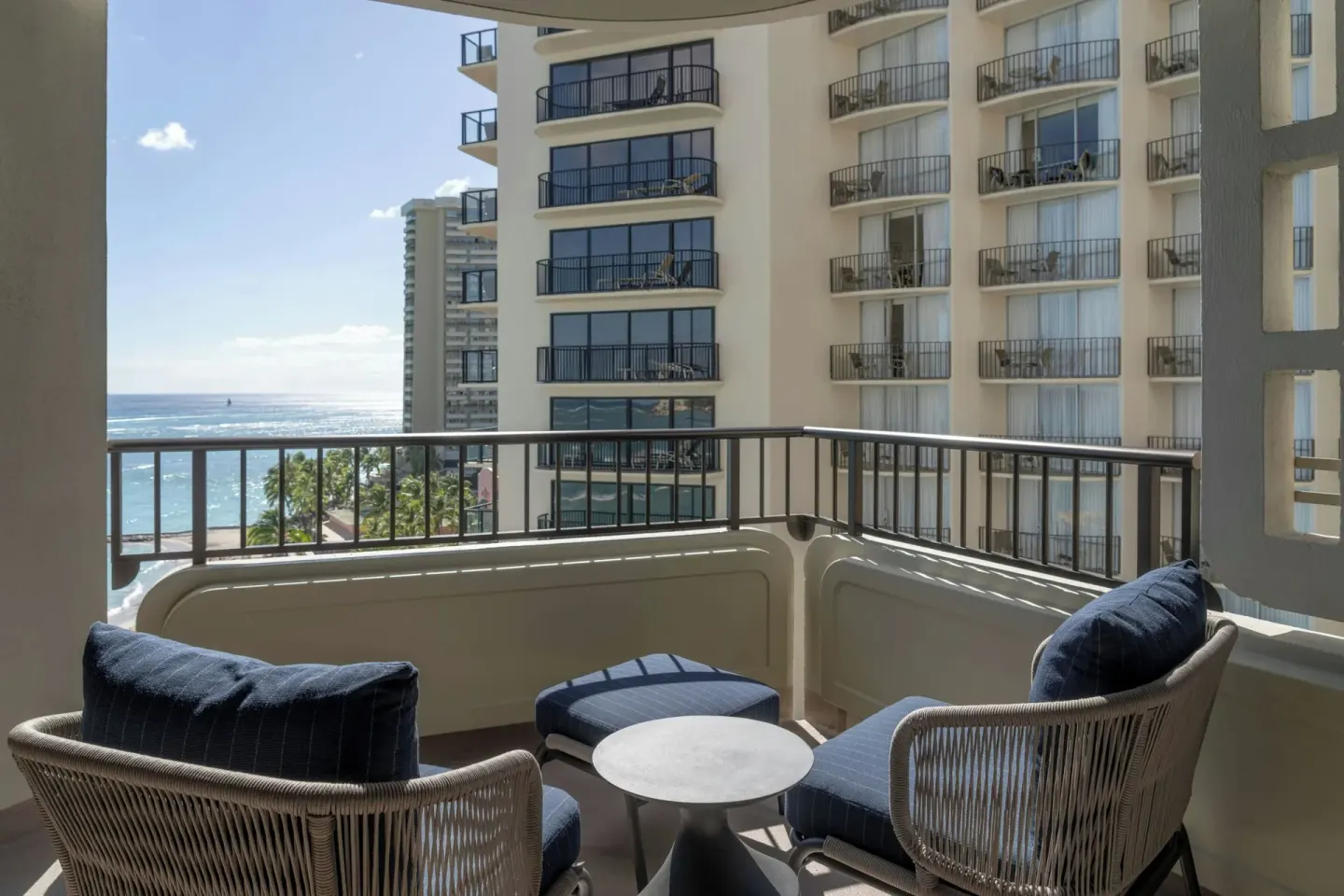 Balcony seating with partial ocean and neighboring tower views at Moana Surfrider, A Westin Resort & Spa.