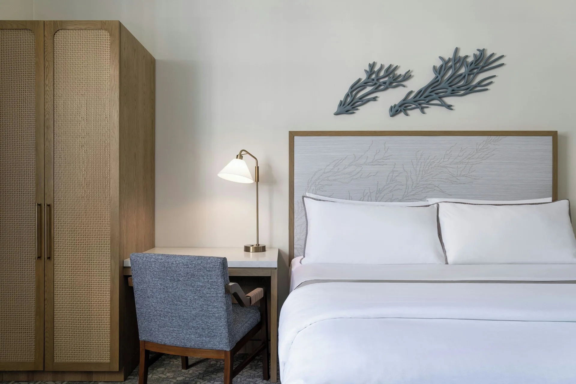 King bed, desk and cane-front wardrobe in a guest room at Moana Surfrider, A Westin Resort & Spa.
