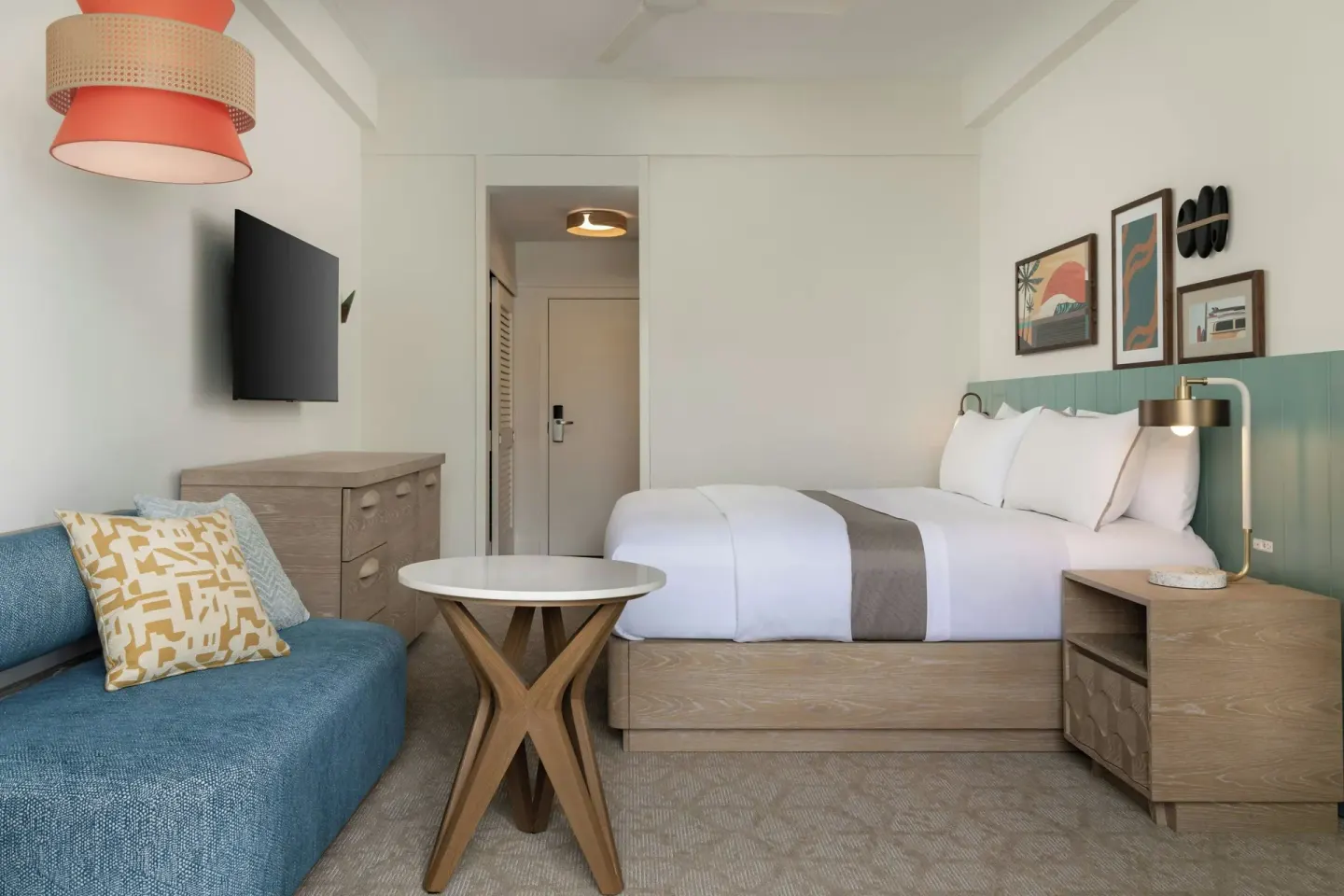Guest room with king bed, sofa, and round table at Moana Surfrider, A Westin Resort & Spa.