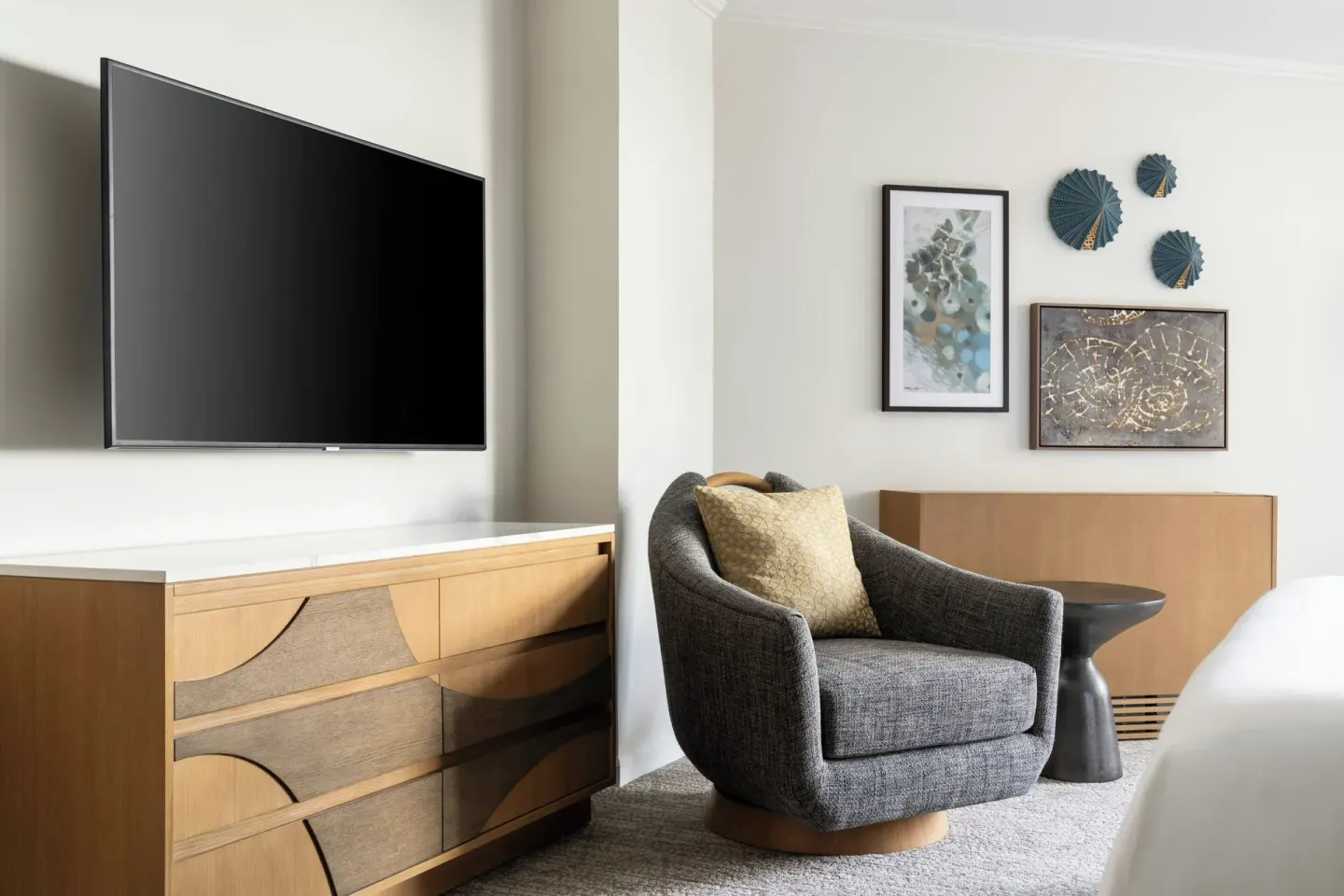 Guest room TV, dresser, and lounge chair at Moana Surfrider, A Westin Resort & Spa.