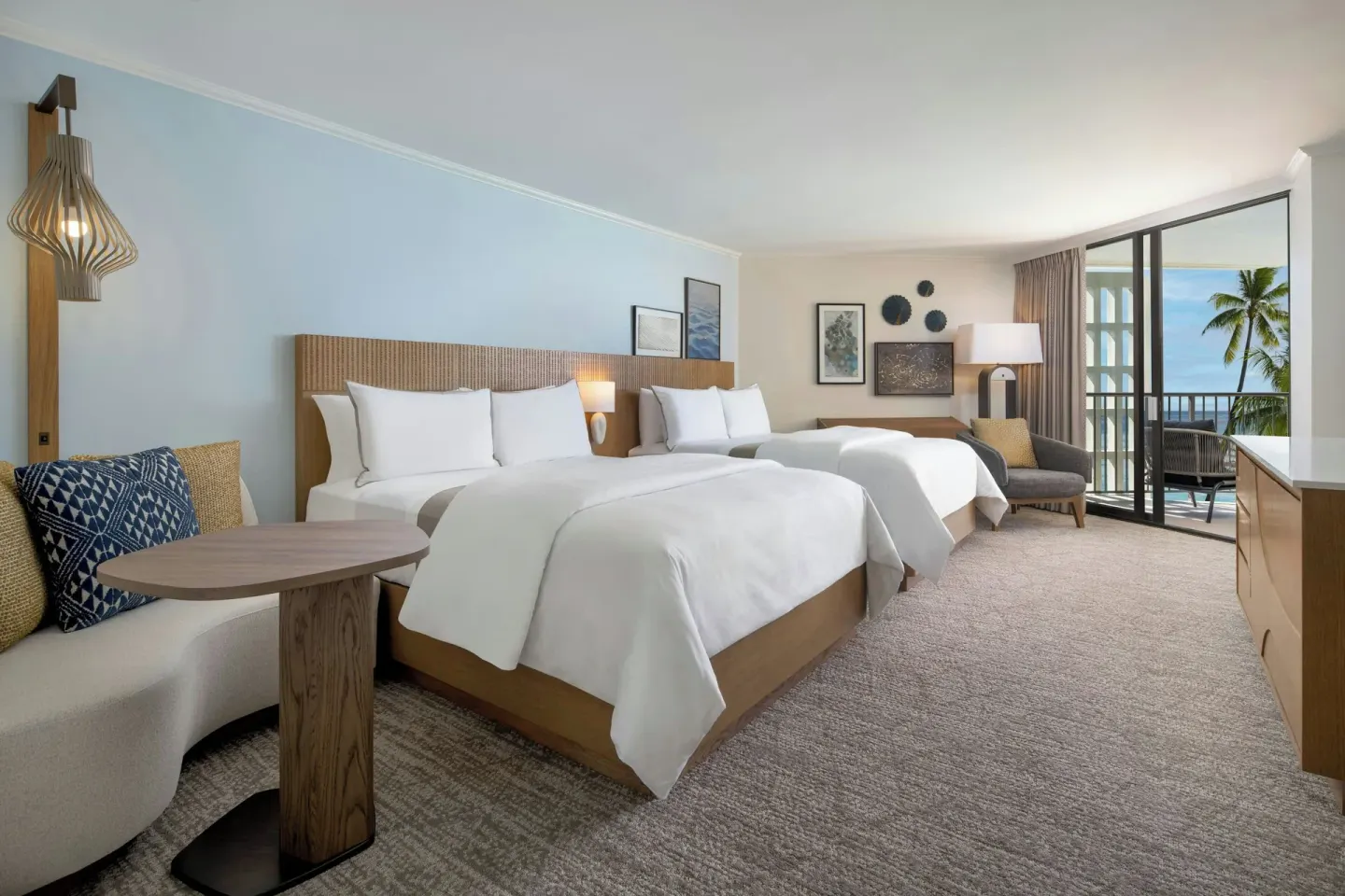 Two-bed guest room with ocean-view balcony at Moana Surfrider, A Westin Resort & Spa.