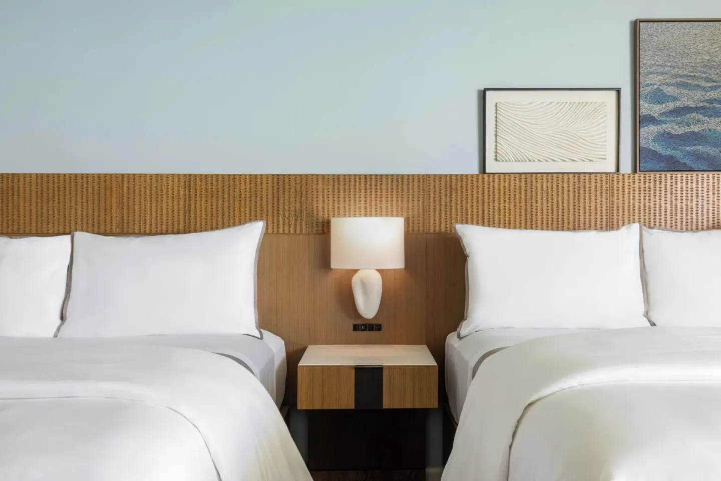 Two beds with shared nightstand at Moana Surfrider, A Westin Resort & Spa.