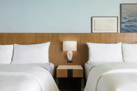Two beds with shared nightstand at Moana Surfrider, A Westin Resort & Spa.