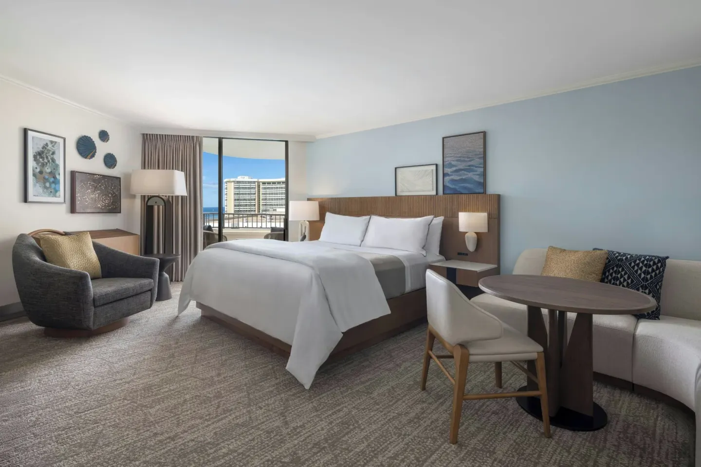 King bed guest room with sofa and balcony at Moana Surfrider, A Westin Resort & Spa.