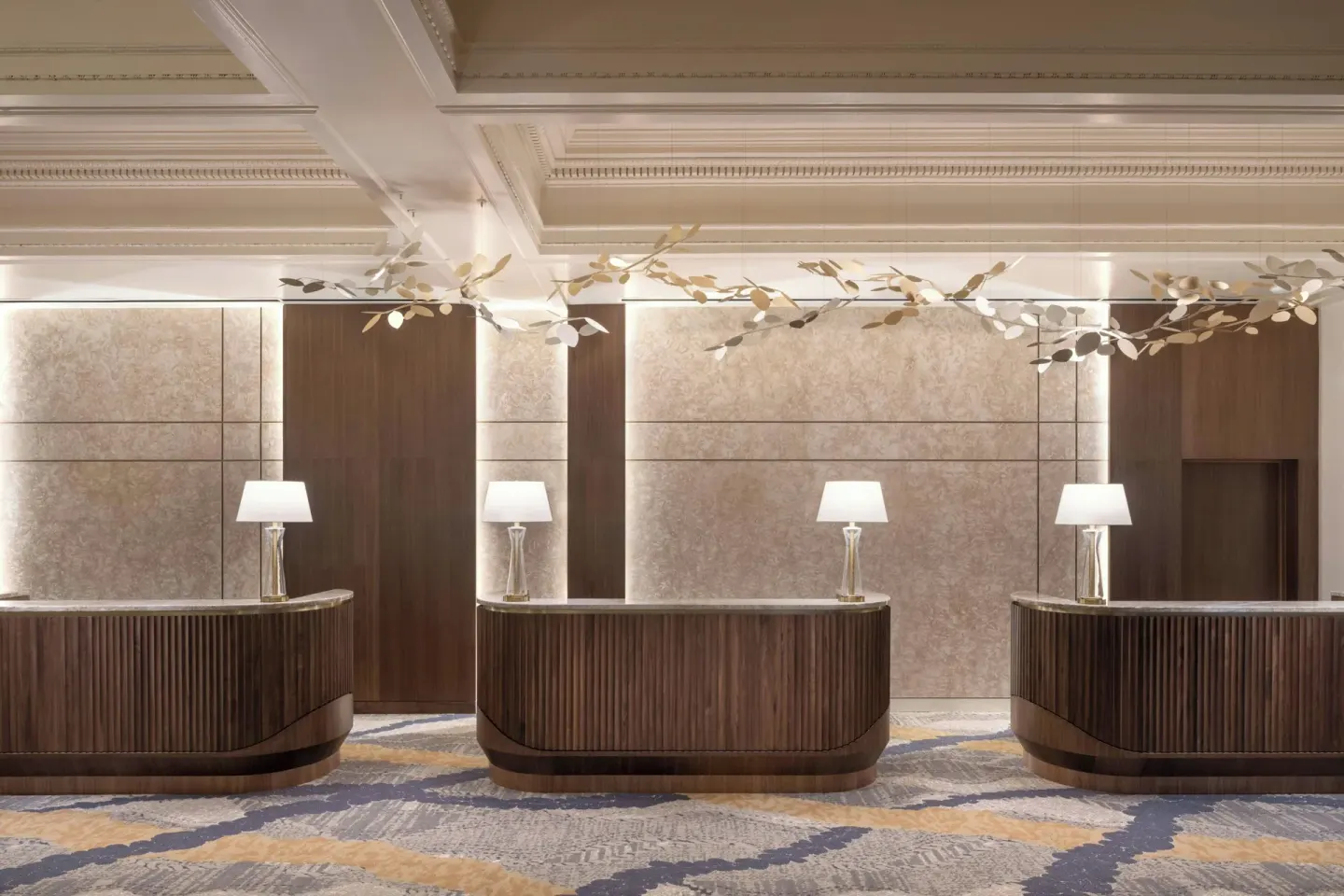 Three wood reception desks in the lobby at Moana Surfrider, A Westin Resort & Spa.