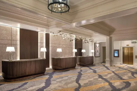 Lobby reception desks and elevator area at Moana Surfrider, A Westin Resort & Spa.