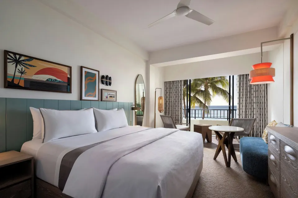 Guest room with king bed and ocean balcony at Moana Surfrider, A Westin Resort & Spa.