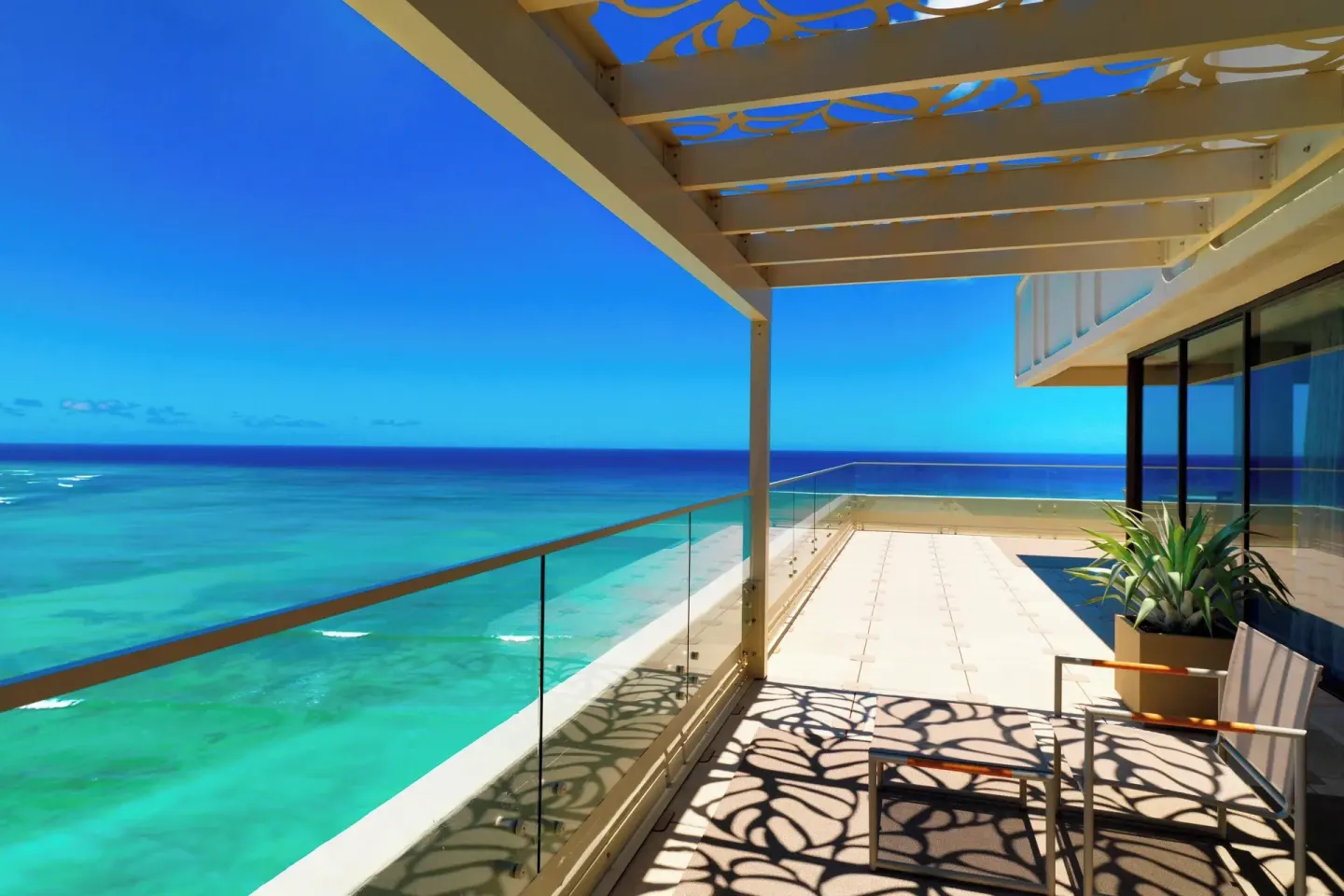 Oceanfront balcony with glass railing at Moana Surfrider, A Westin Resort & Spa.