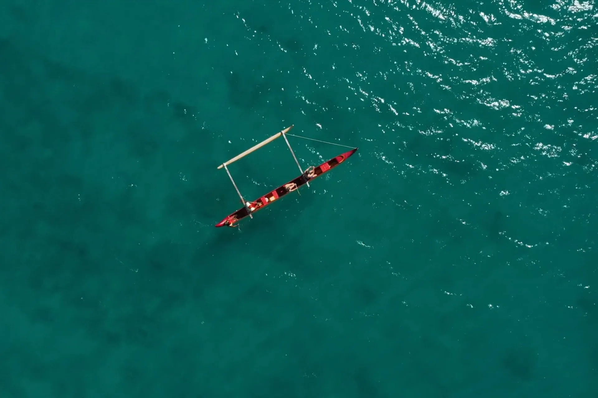 Outrigger canoe on turquoise water near Moana Surfrider, A Westin Resort & Spa.