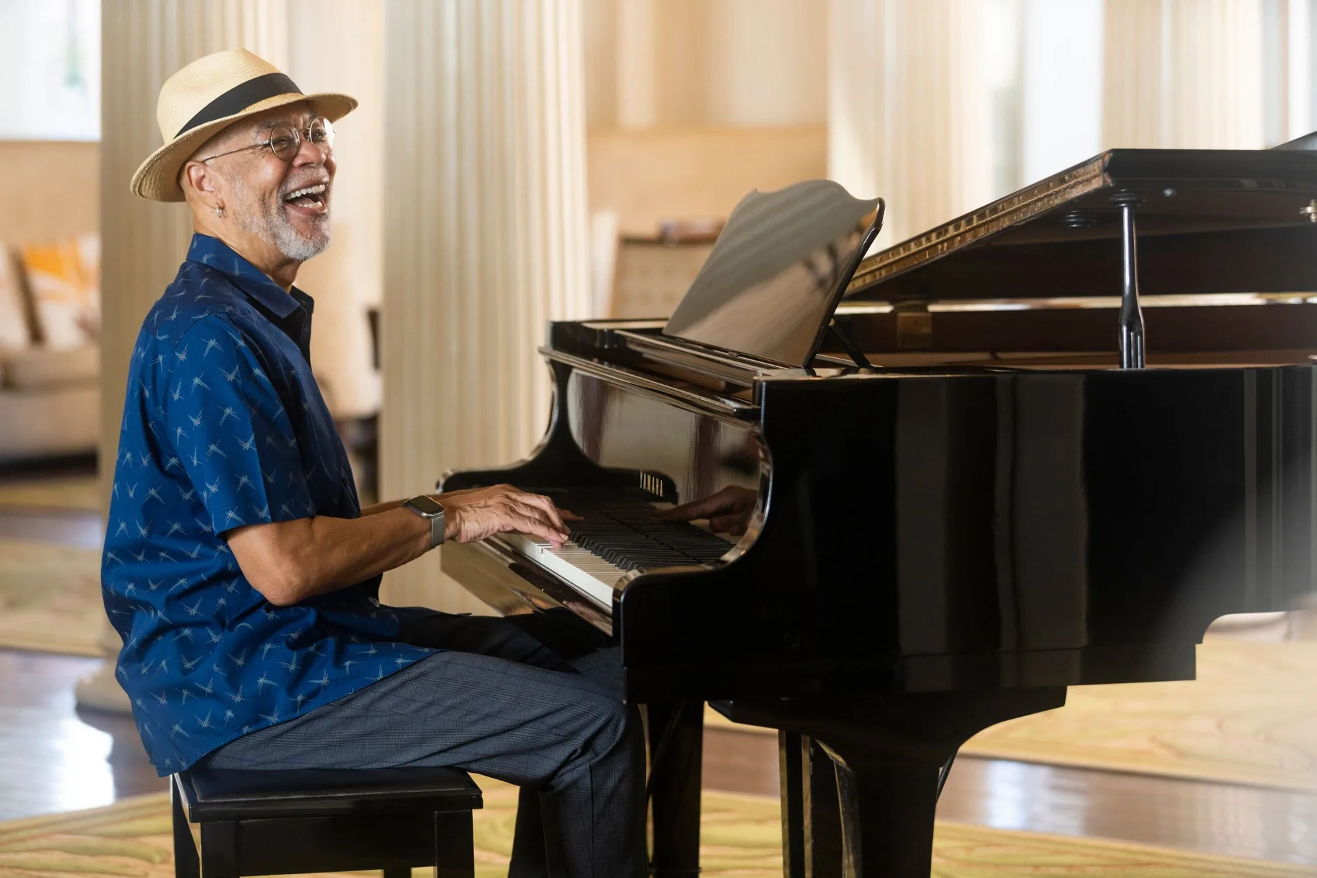 A pianist plays a grand piano at Moana Surfrider, A Westin Resort & Spa.