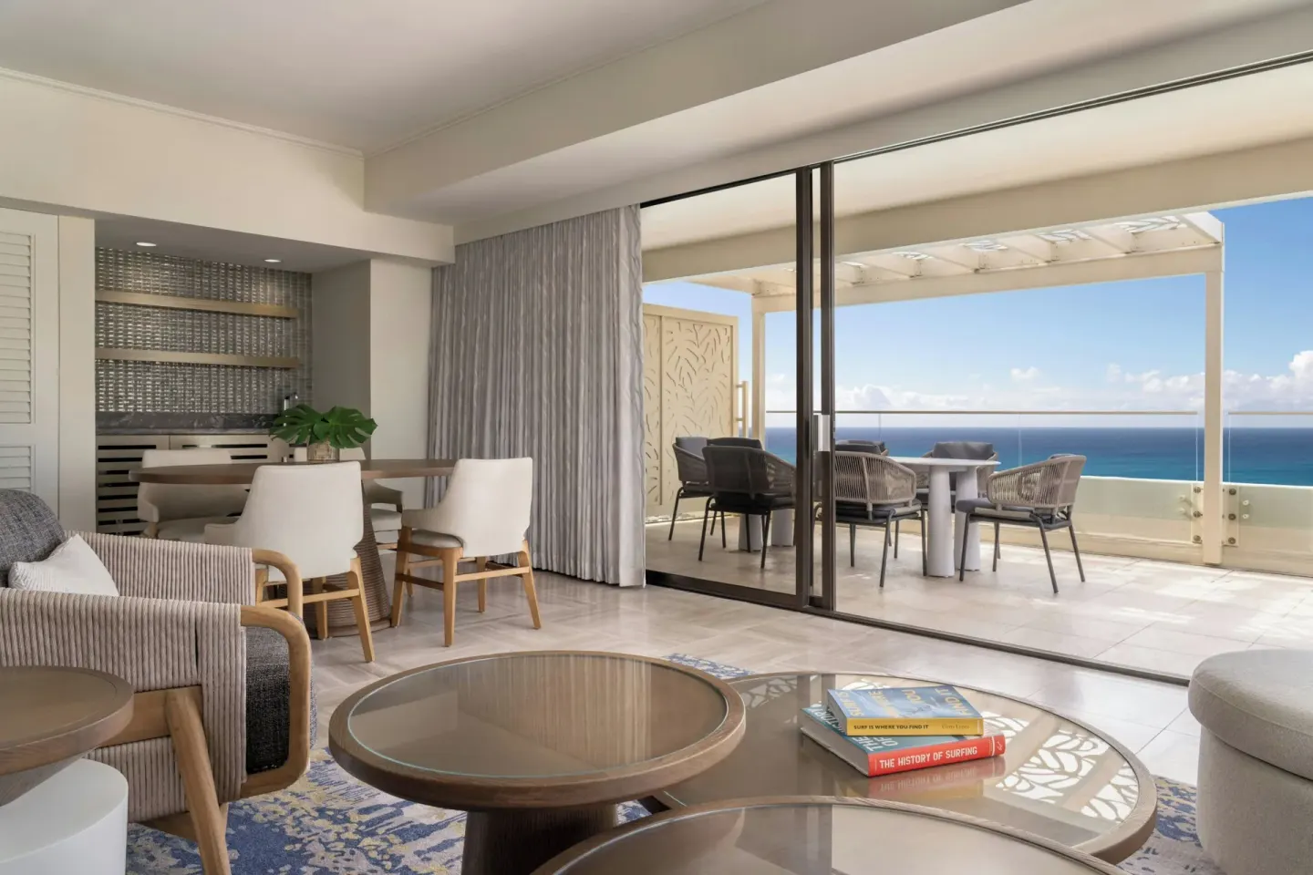 Suite living area opening to a furnished ocean-view terrace at Moana Surfrider, A Westin Resort & Spa.