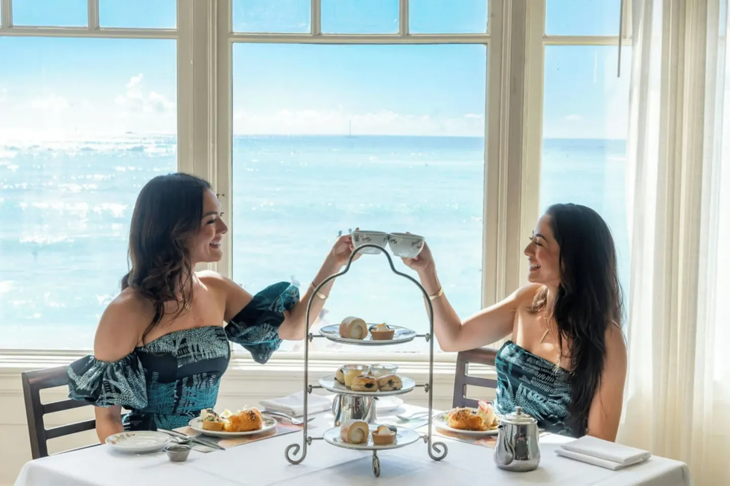Afternoon tea by oceanfront windows at Moana Surfrider, A Westin Resort & Spa.