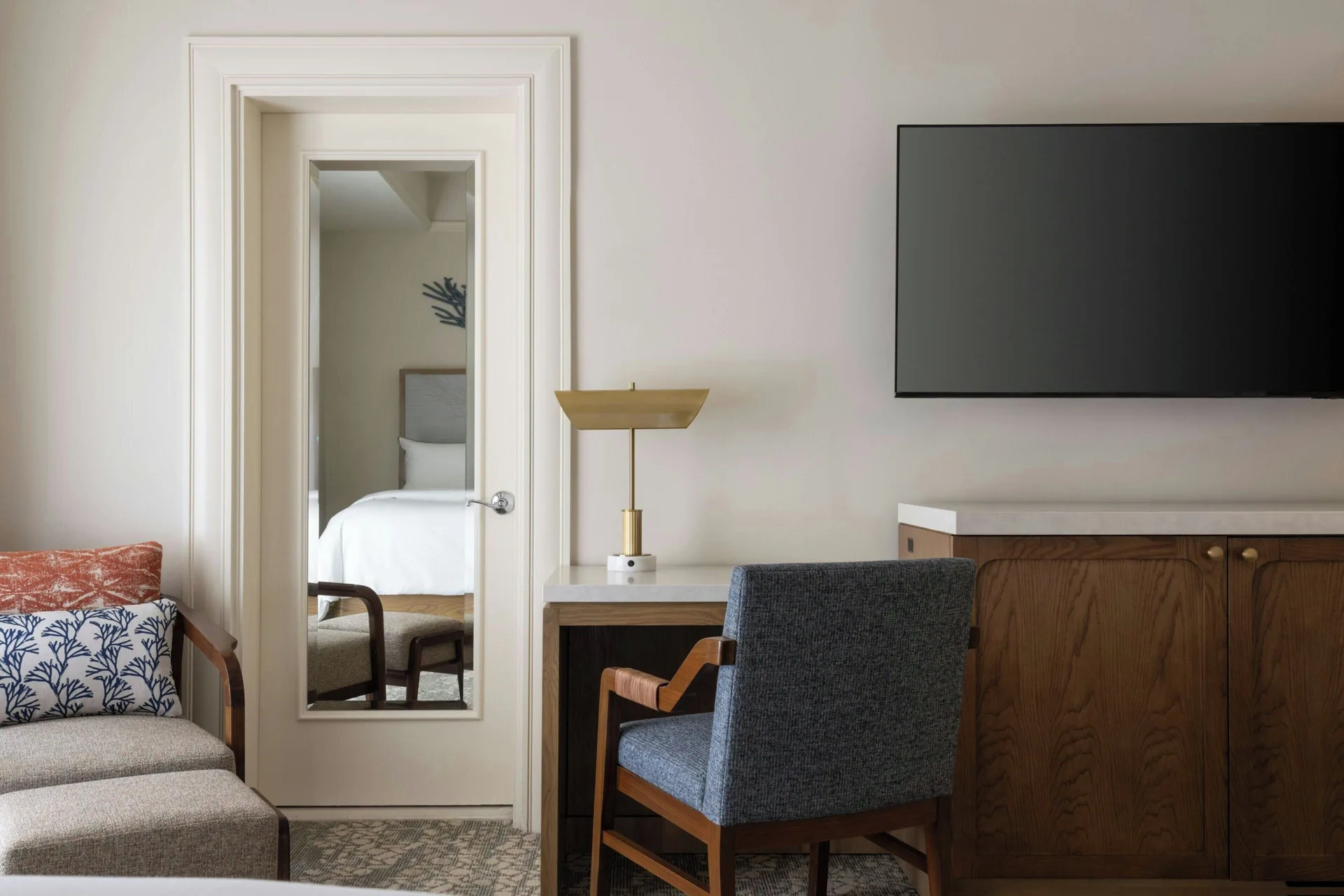 Banyan Deluxe Room desk, chair, sofa, mirror, and TV at Moana Surfrider, A Westin Resort & Spa.