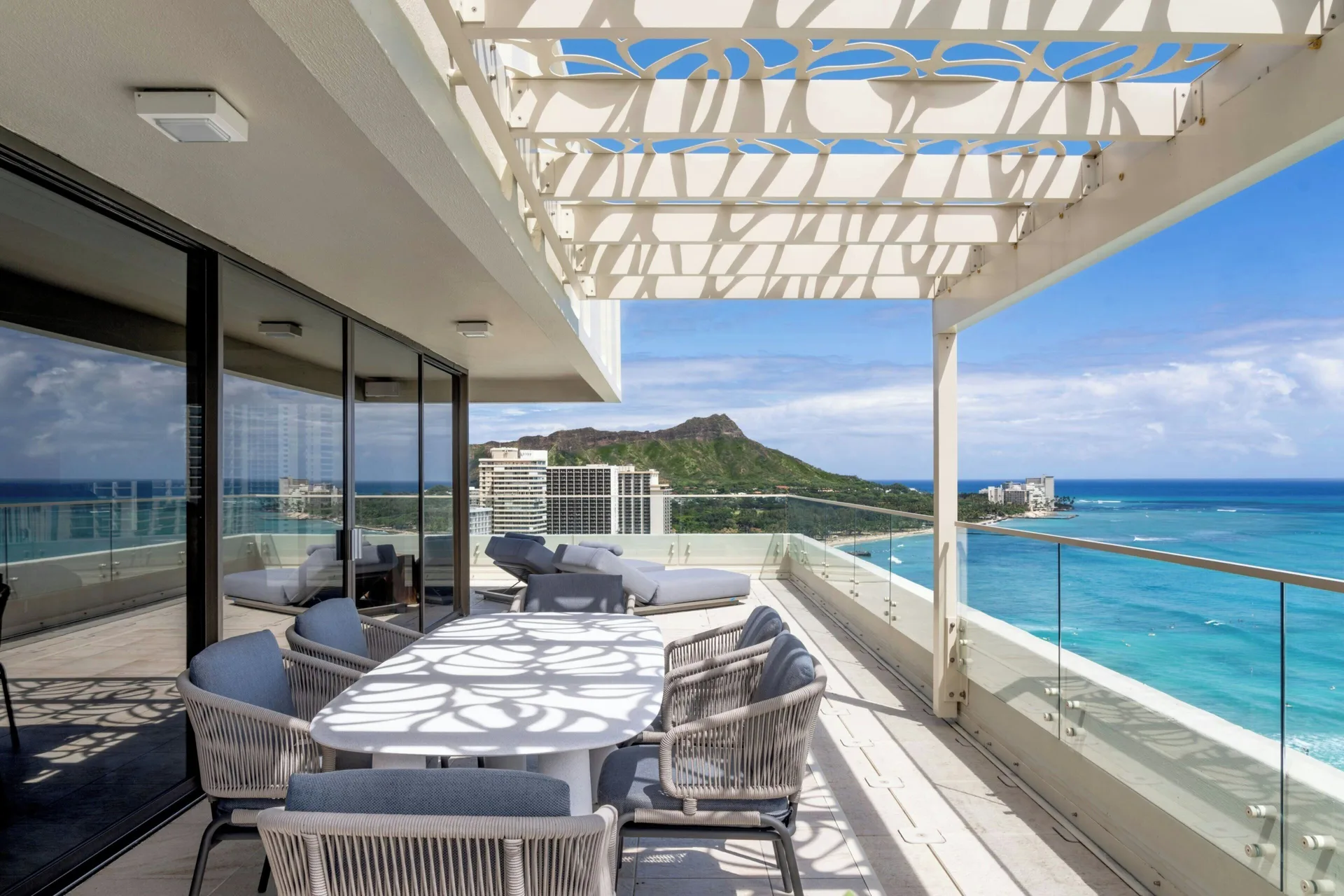 Penthouse Ocean Suite terrace at Moana Surfrider, A Westin Resort & Spa with dining table, loungers, ocean, and Diamond Head.