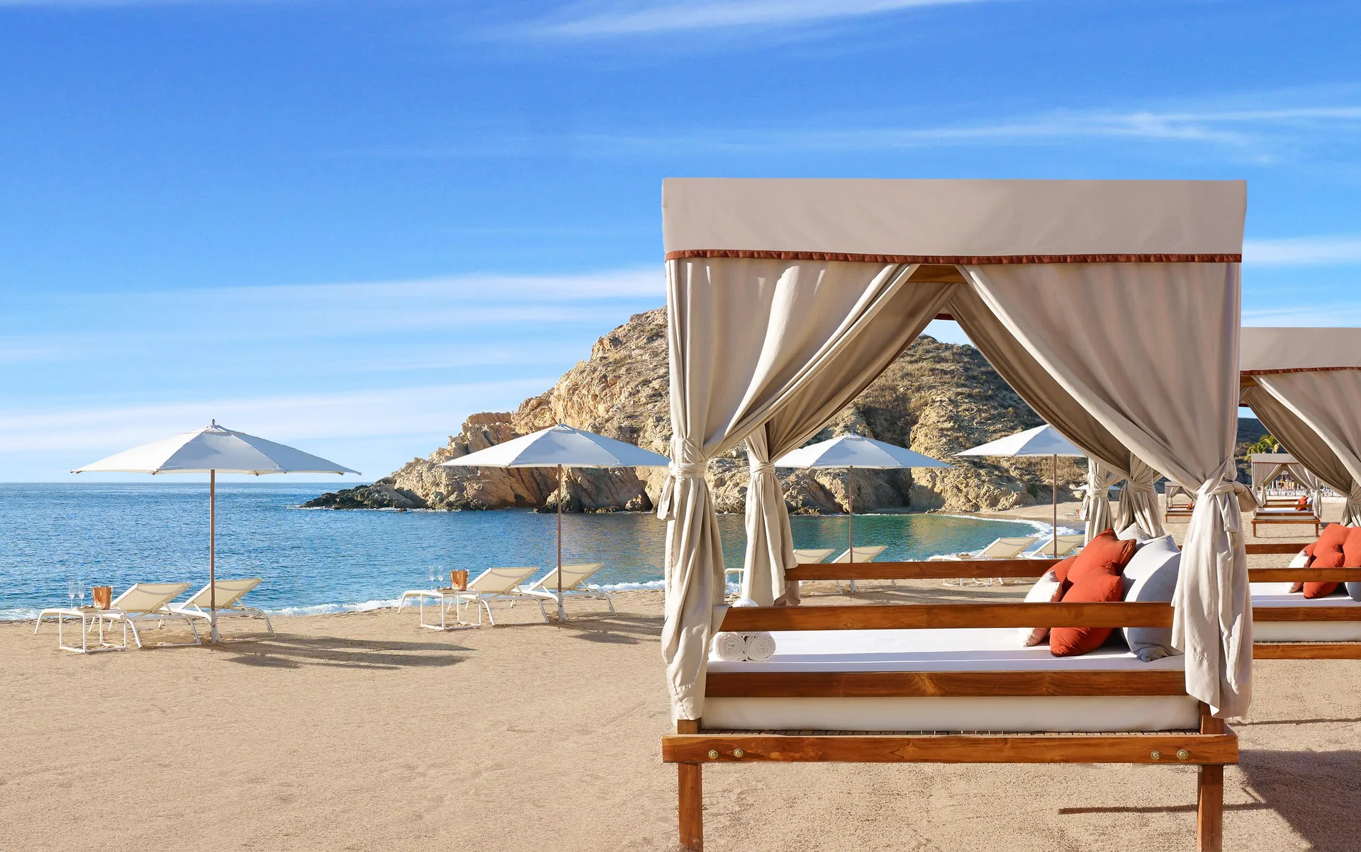 Beach cabana with lounge seating, umbrellas, and bay view at Montage Los Cabos.