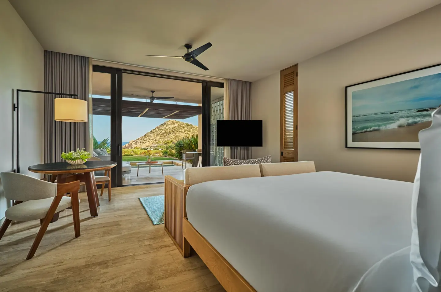 King bed guest room with dining table and terrace at Montage Los Cabos.