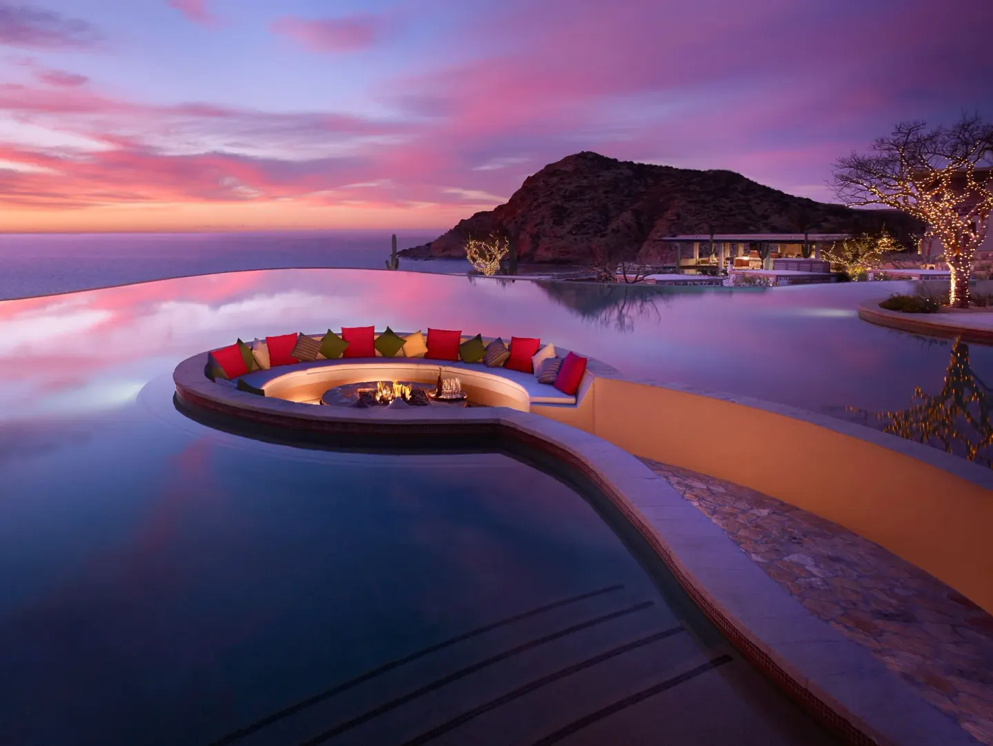 Infinity pool fire pit lounge at sunset at Montage Los Cabos.