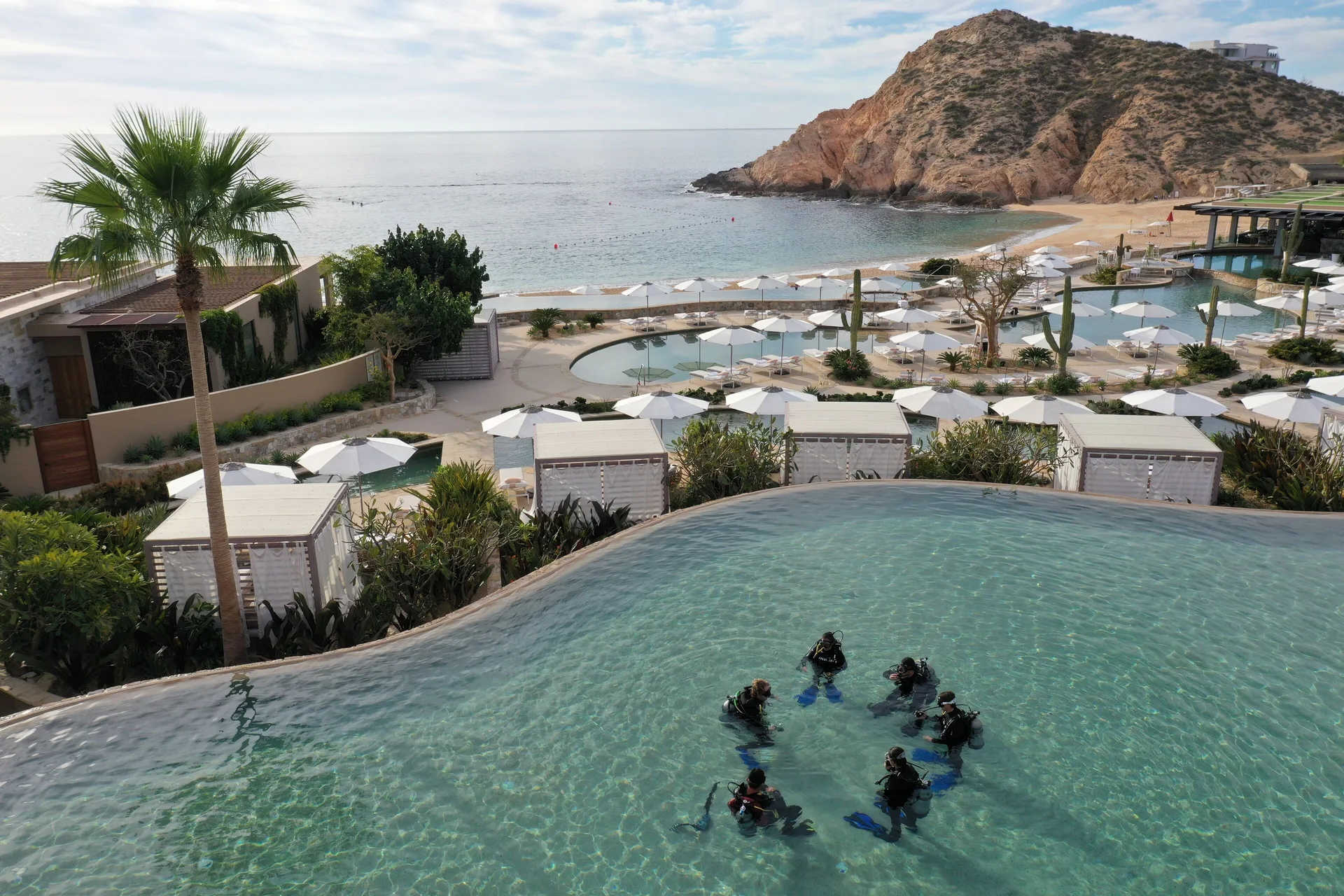 Snorkelers gather in an infinity pool above the beach at Montage Los Cabos.
