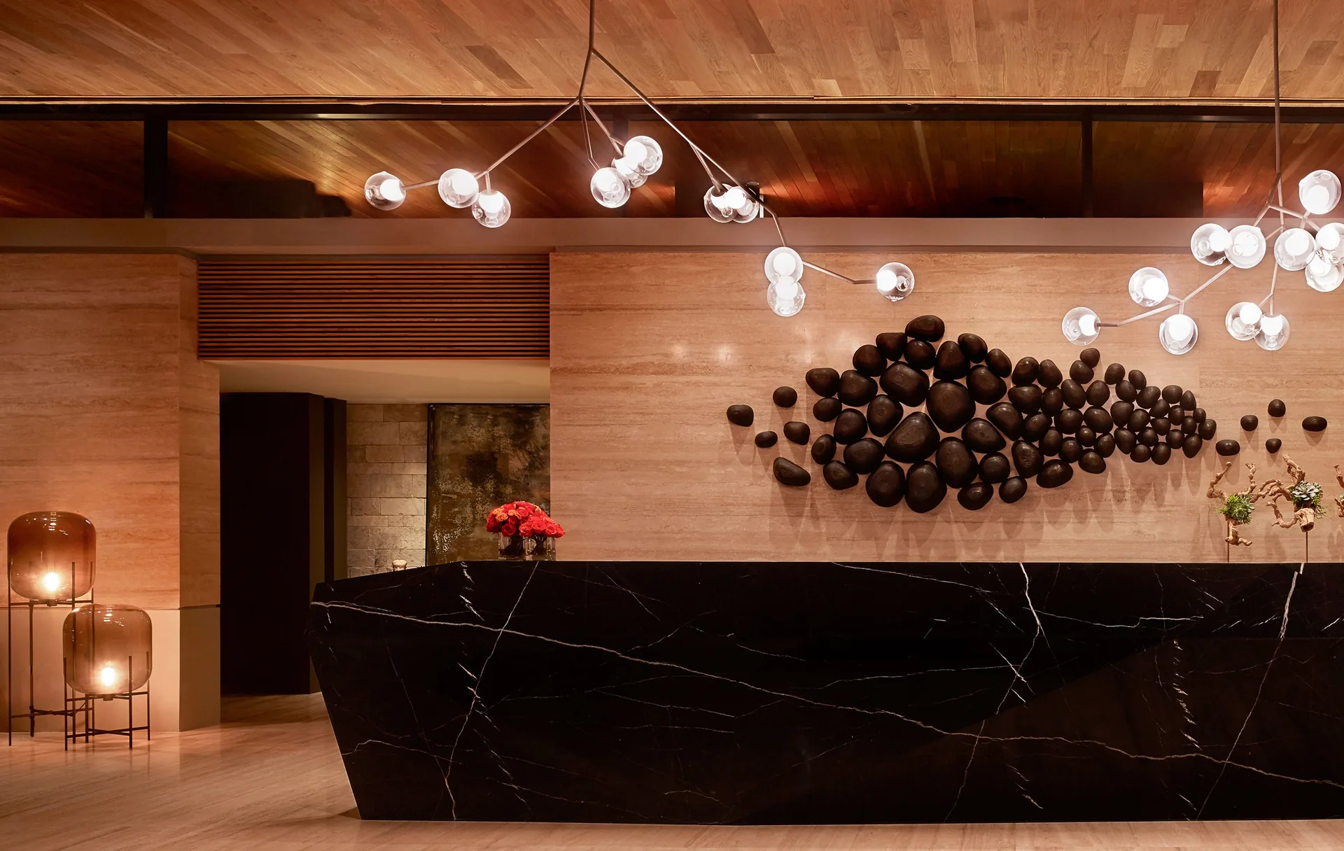 Lobby reception desk with sculptural wall art and pendant lights at Montage Los Cabos.