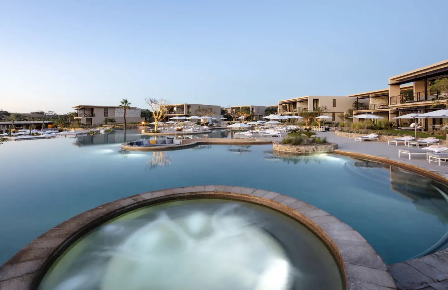 Resort pool with circular spa and white loungers at Montage Los Cabos.