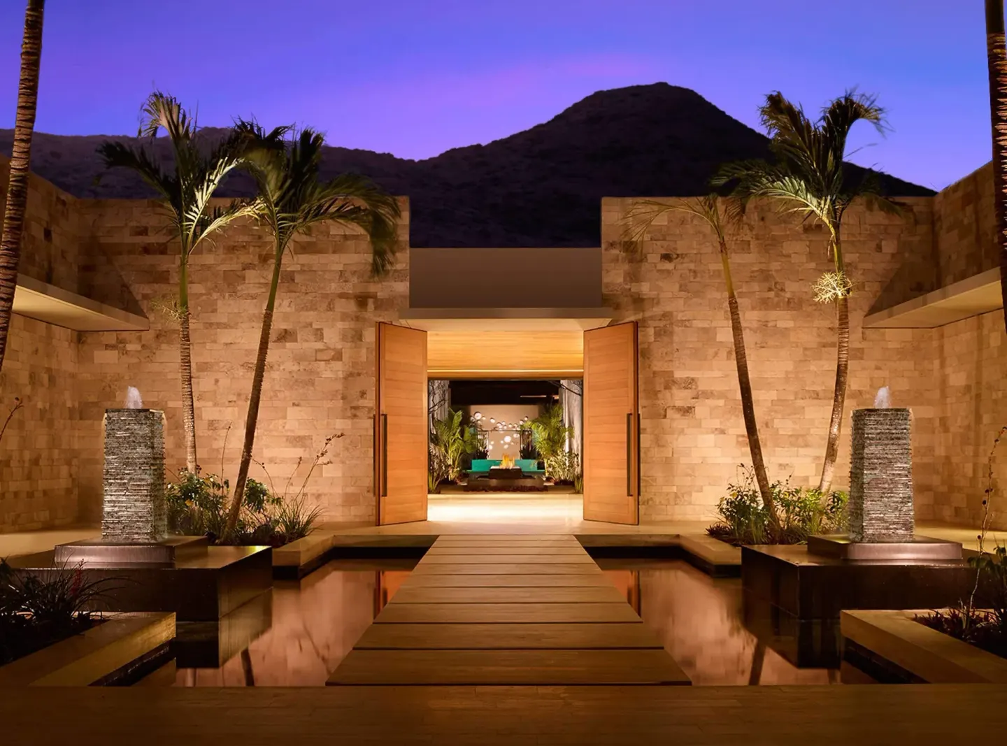 Stone spa courtyard with palms, reflecting pools, and open doors at Montage Los Cabos.