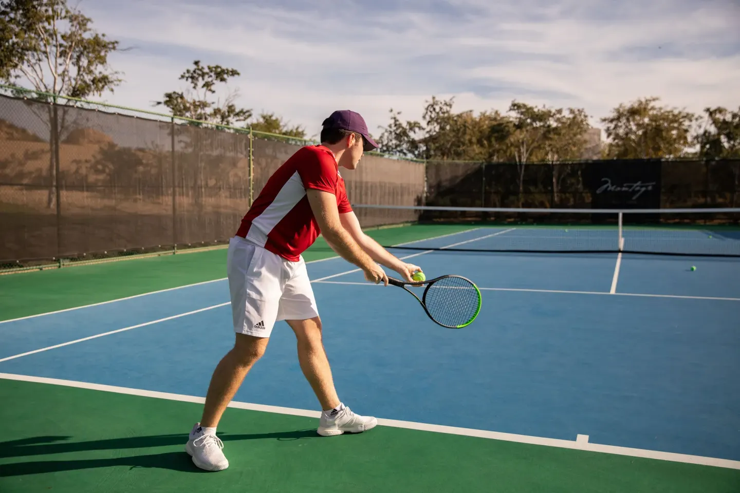 Tennis player preparing to serve on an outdoor court at Montage Los Cabos.