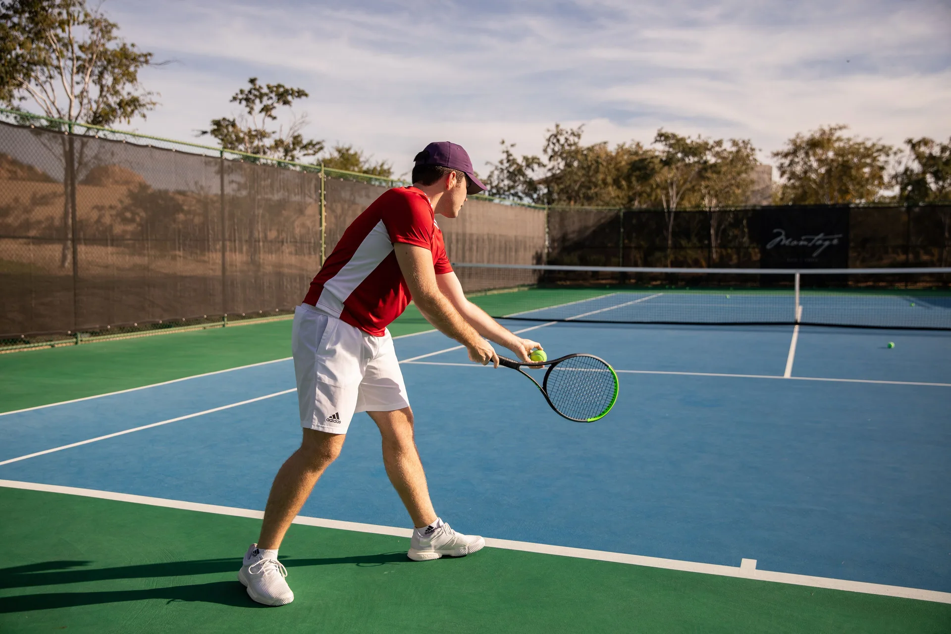 Tennis player preparing to serve on an outdoor court at Montage Los Cabos.