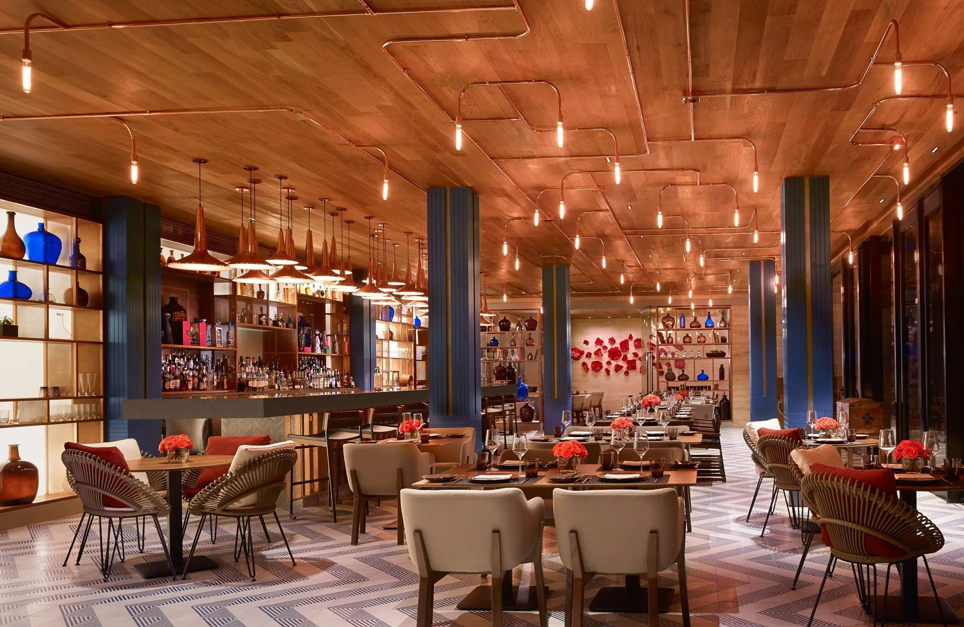 Warmly lit restaurant dining room and bar at Montage Los Cabos.