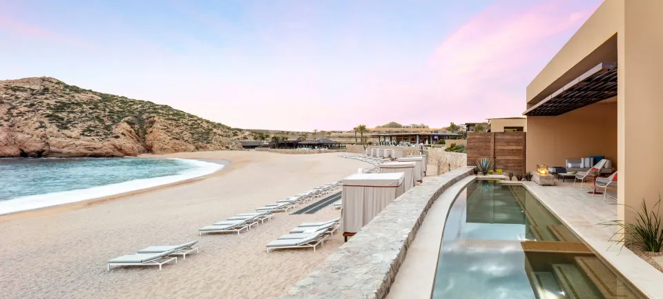 Beachfront suite terrace with long private pool at Montage Los Cabos at dusk.
