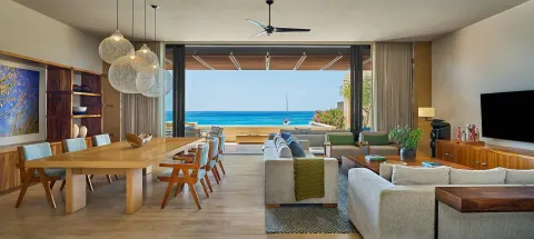 Living and dining room with open terrace and ocean view at Montage Los Cabos.