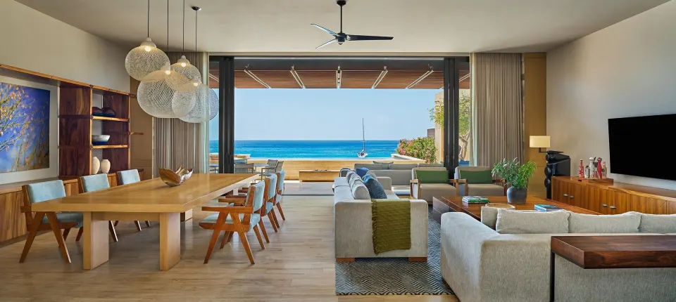 Living and dining room with open terrace and ocean view at Montage Los Cabos.