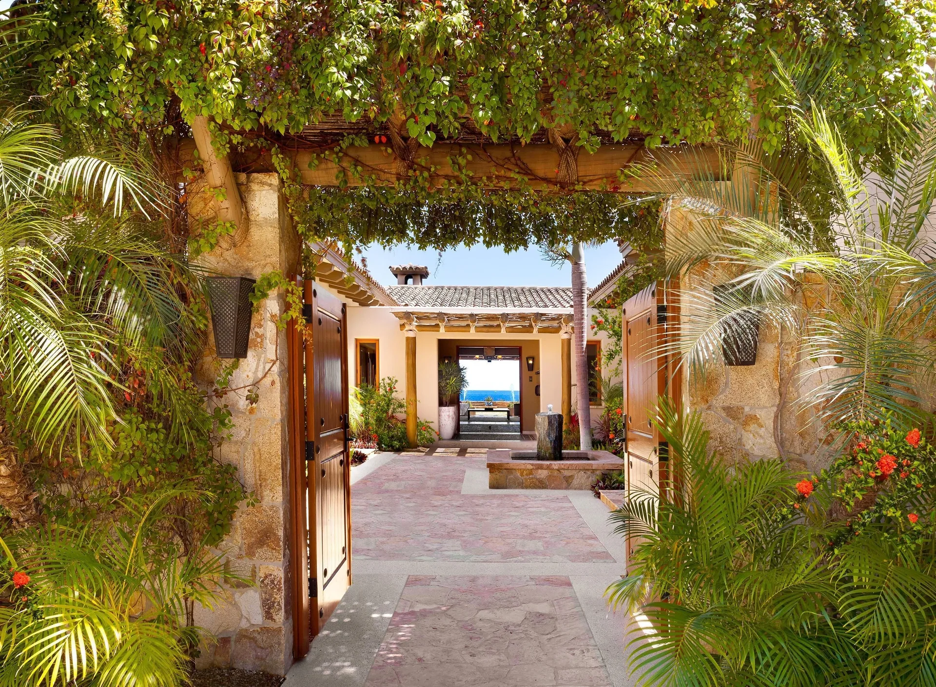Casa Cardon garden entry gate frames a courtyard and ocean view at Montage Los Cabos.