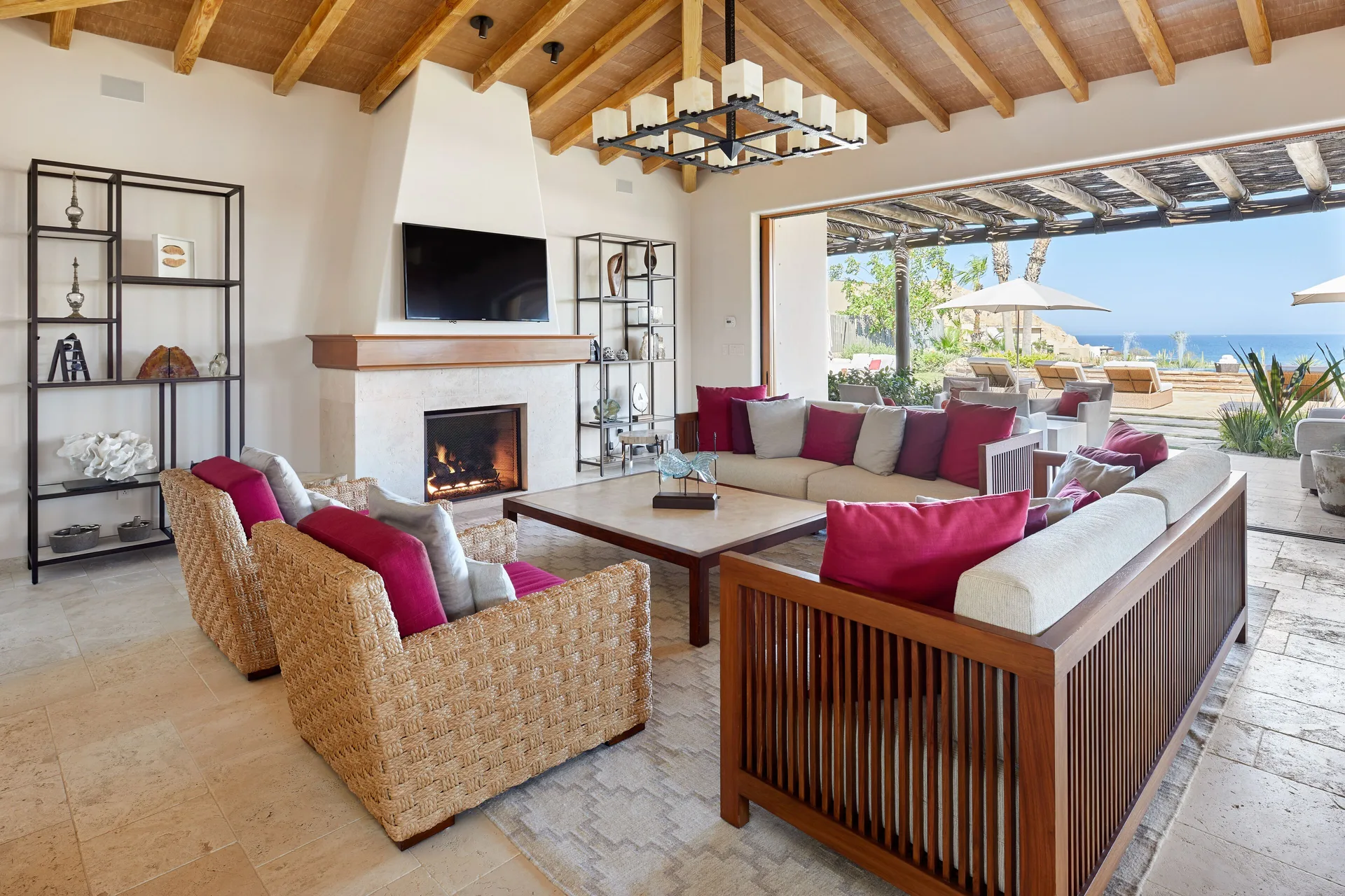 Living room in Casa Cardon Five Bedroom Home at Montage Los Cabos with fireplace and open terrace doors.