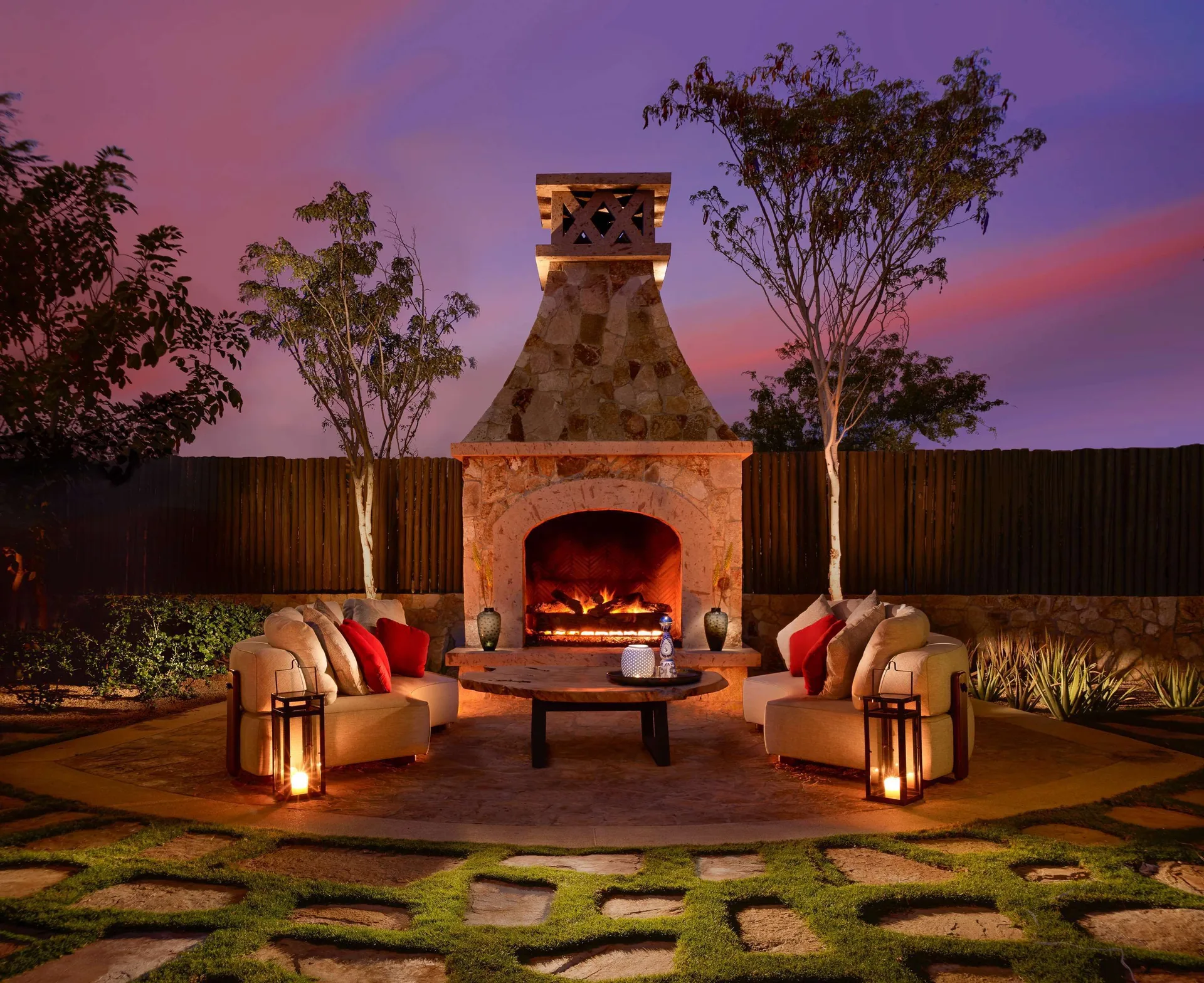 Outdoor fireplace seating area at Casa Cardon Five Bedroom Home at Montage Los Cabos at dusk.