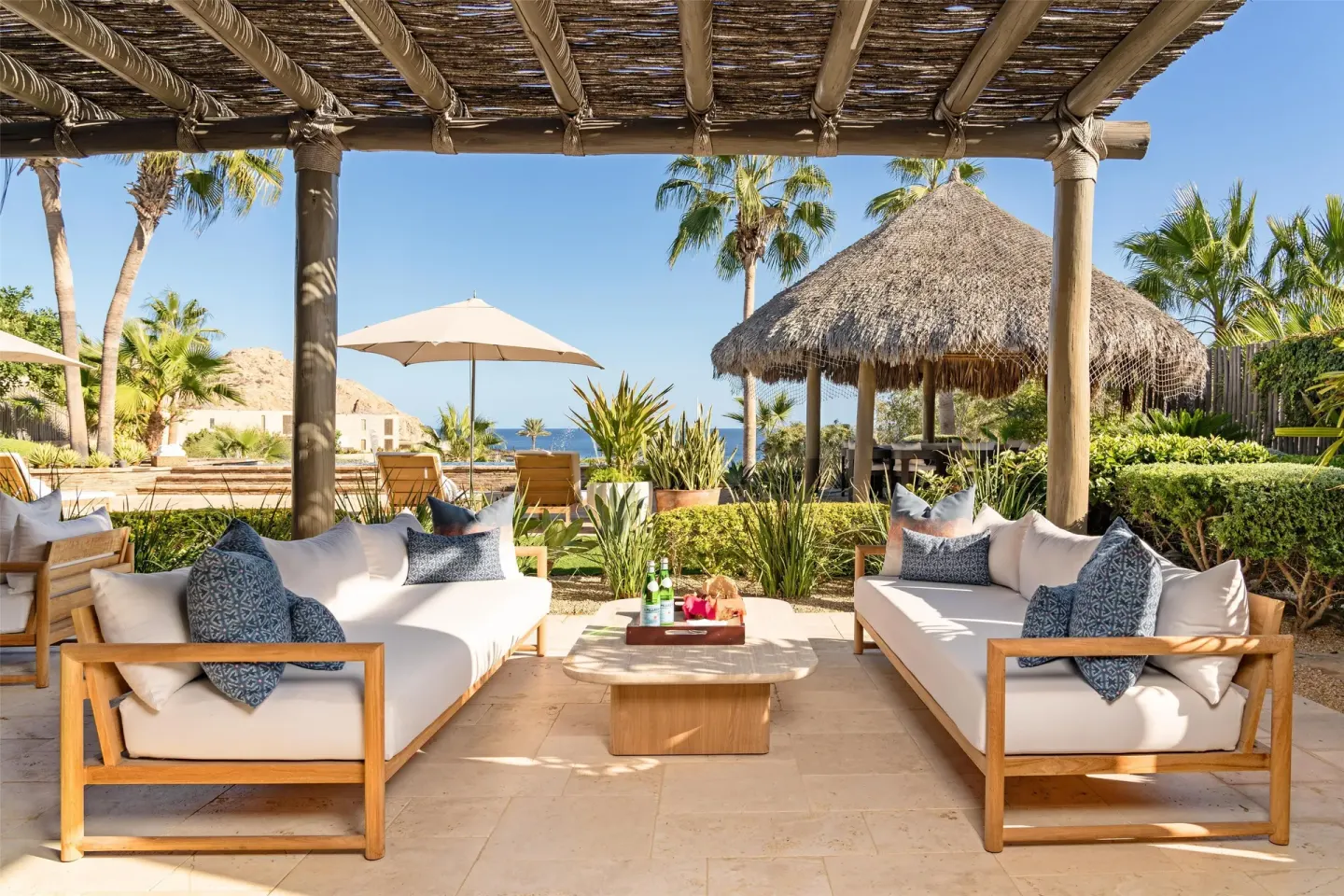Shaded terrace seating at Casa Cardon Five Bedroom Home at Montage Los Cabos with ocean beyond.