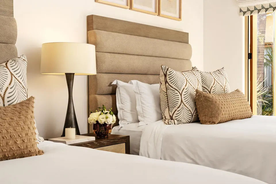 Two-bed guest bedroom in Casa Cardon Five Bedroom Home at Montage Los Cabos with patterned pillows.