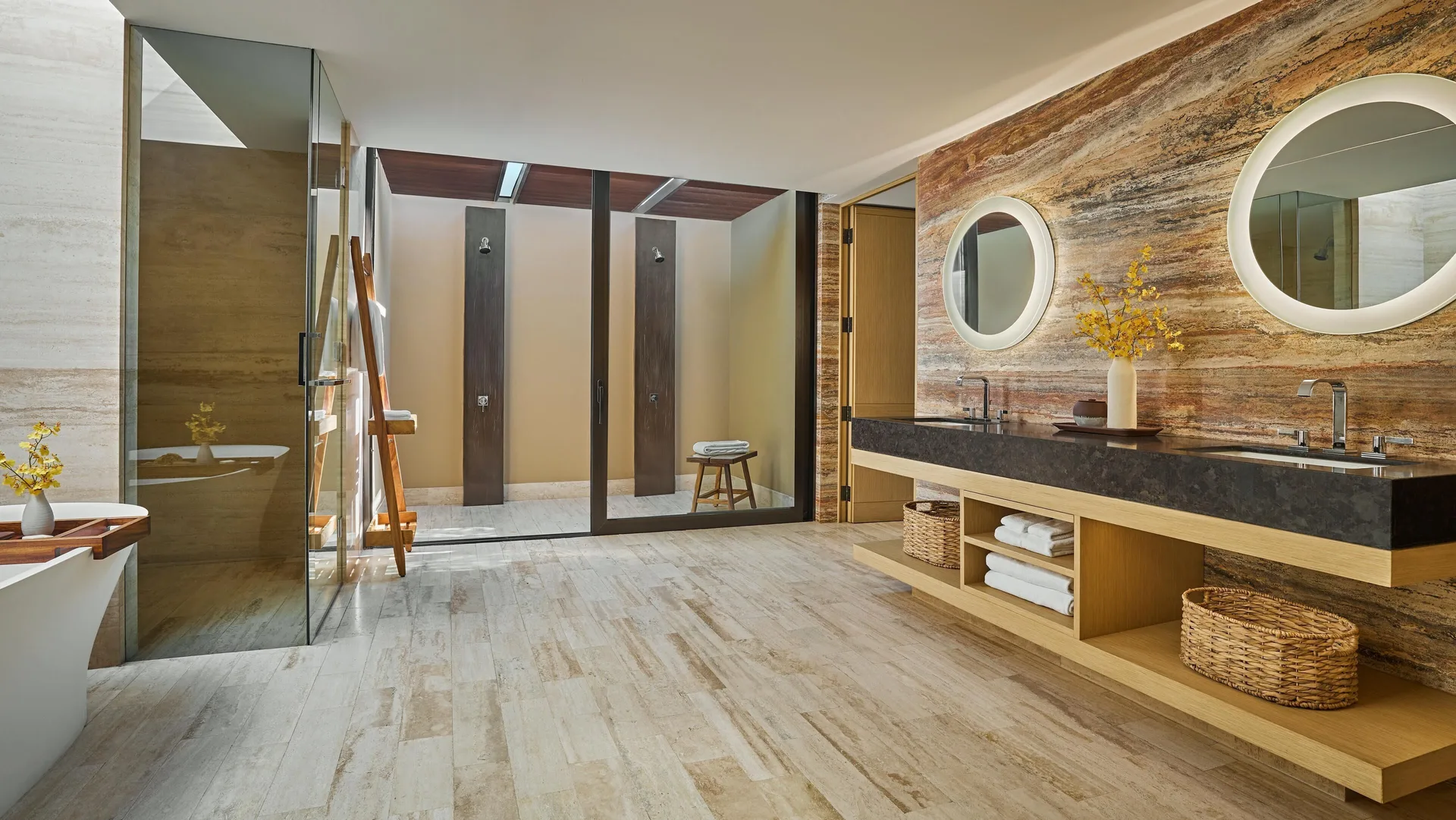 Casa Dolphin bathroom at Montage Los Cabos with double vanity, round mirrors, tub, and showers.